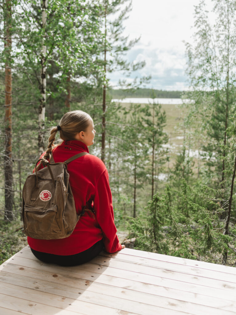 Nainen istuu Ahveroisen näköalapaikalla.