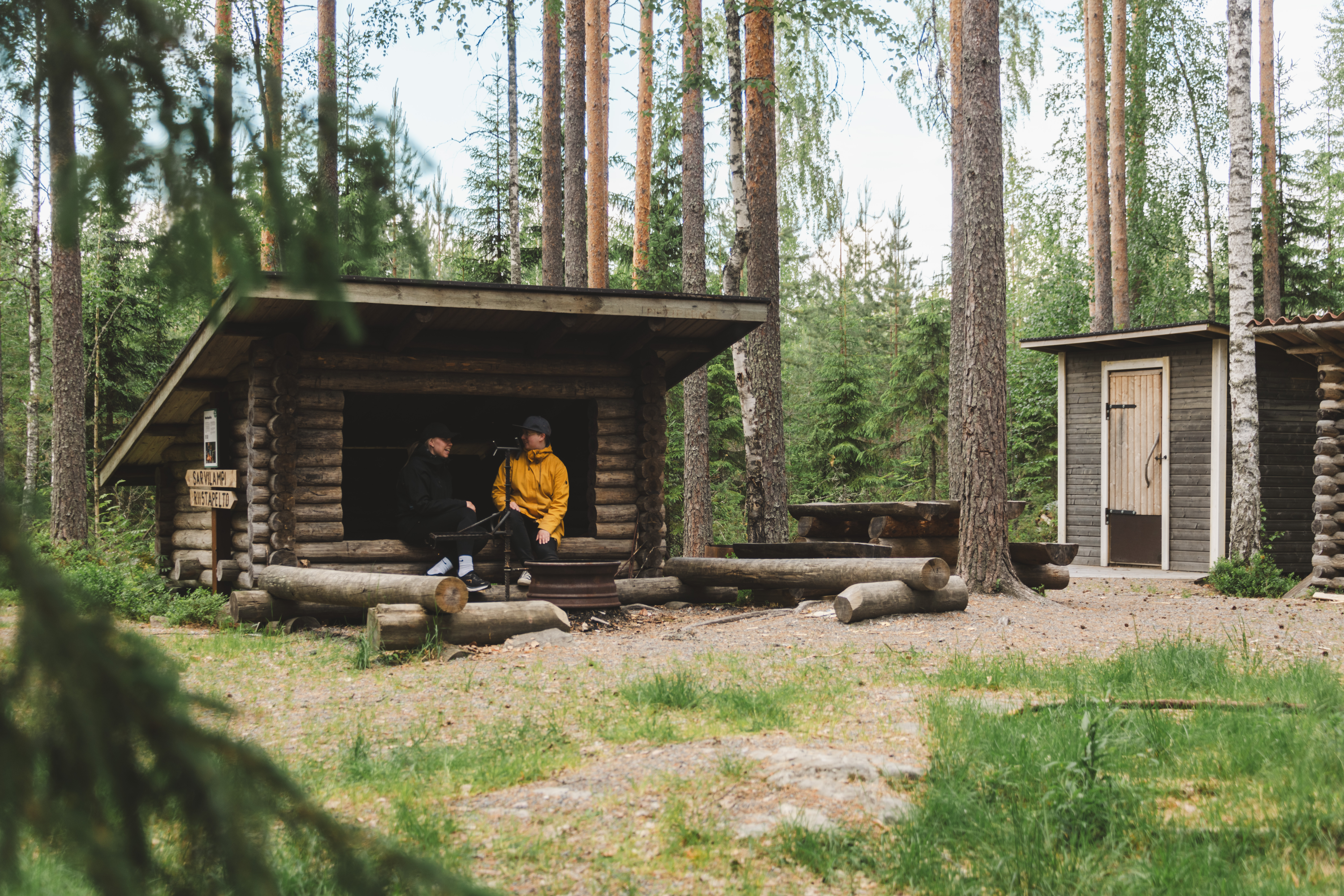 Rapeikon luontopolun laavulla kaksi retkeilijää.